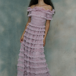 Woman wearing a pink ruffled maxi dress,, designed by BEAUUT