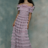 Woman wearing a pink ruffled maxi dress,, designed by BEAUUT