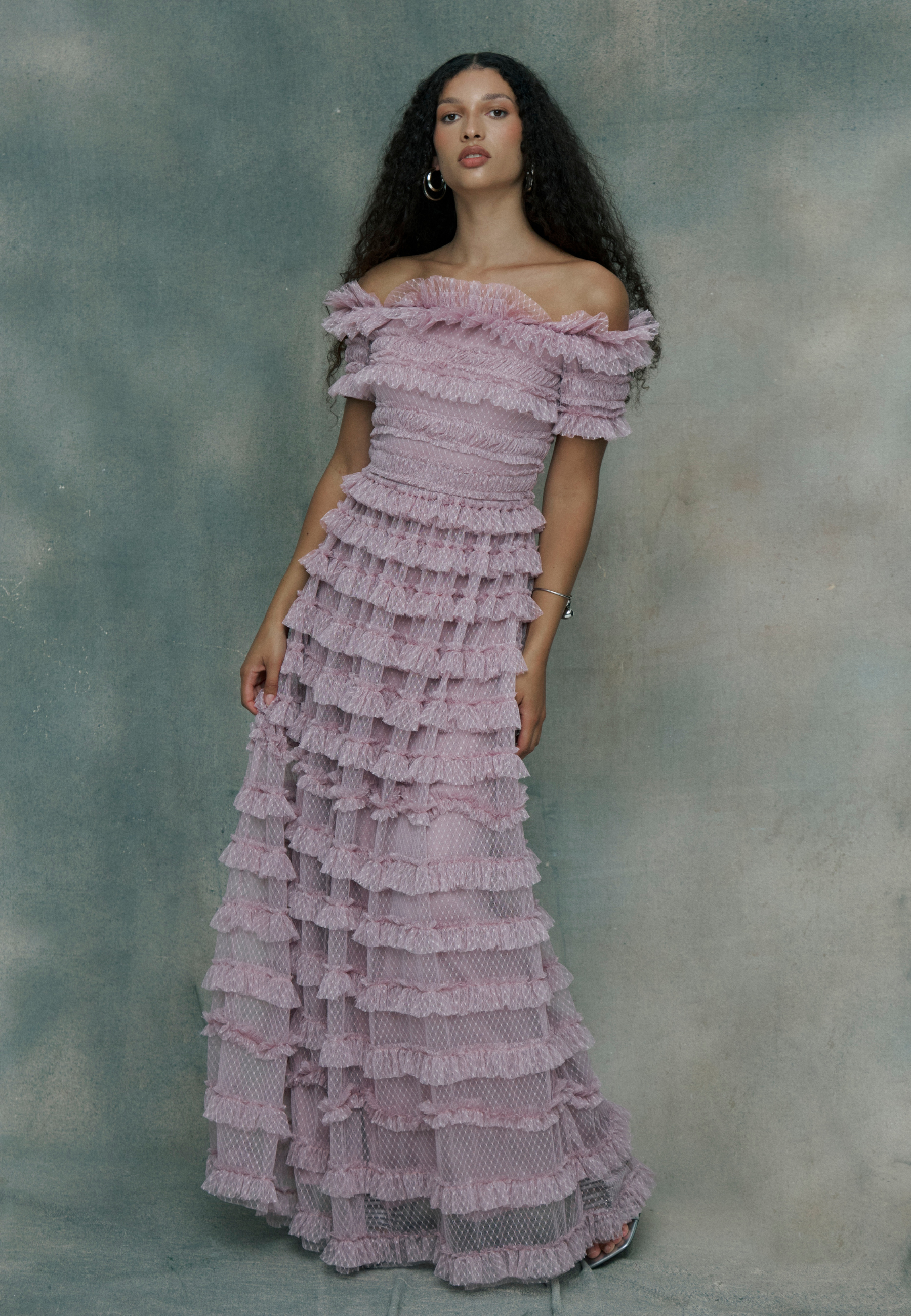 Woman wearing a pink ruffled maxi dress,, designed by BEAUUT