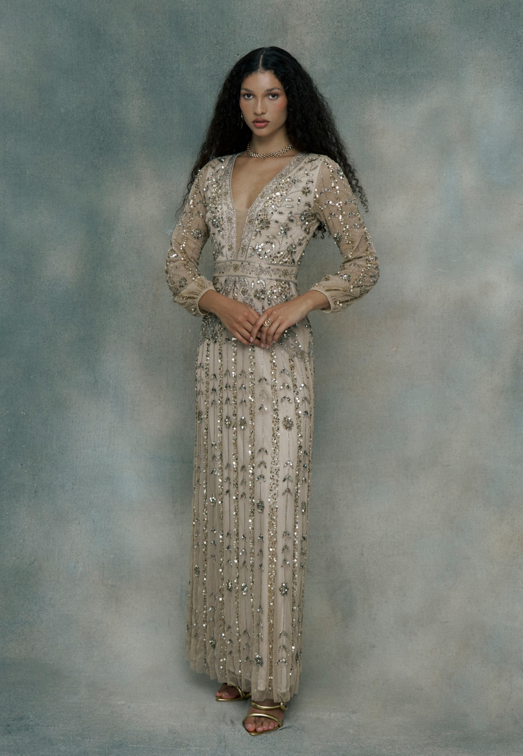 Woman wearing a long, elegant dress with sequins, designed by BEAUUT
