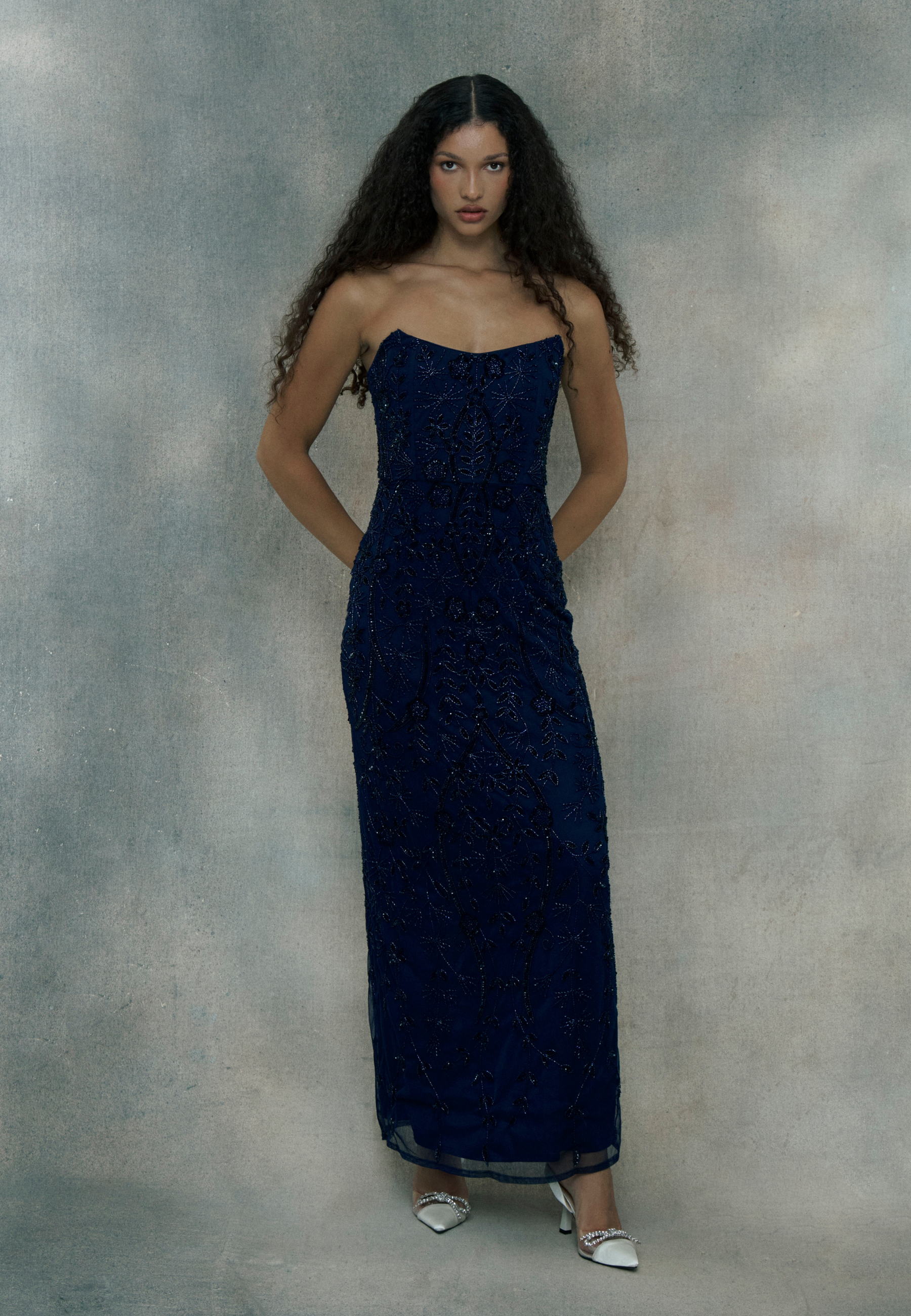 Woman wearing a dark blue strapless gown, designed by BEAUUT
