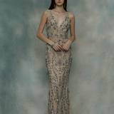 Woman wearing a sparkling evening gown against a textured gray background