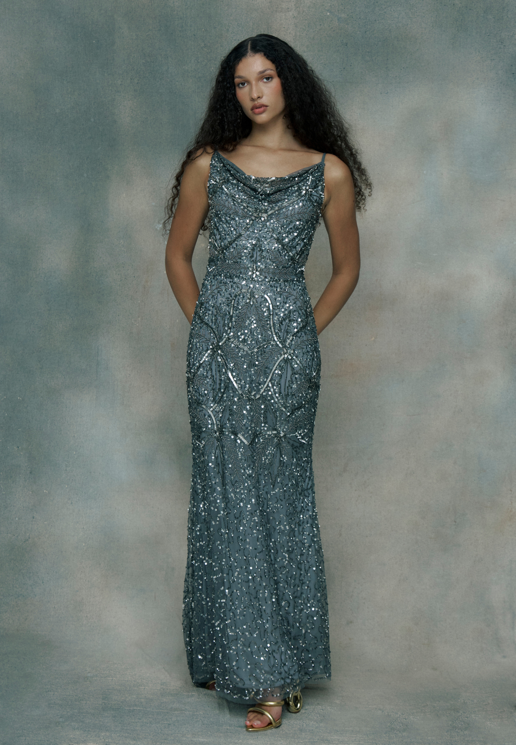 Woman wearing a sparkly silver evening gown, designed by BEAUUT