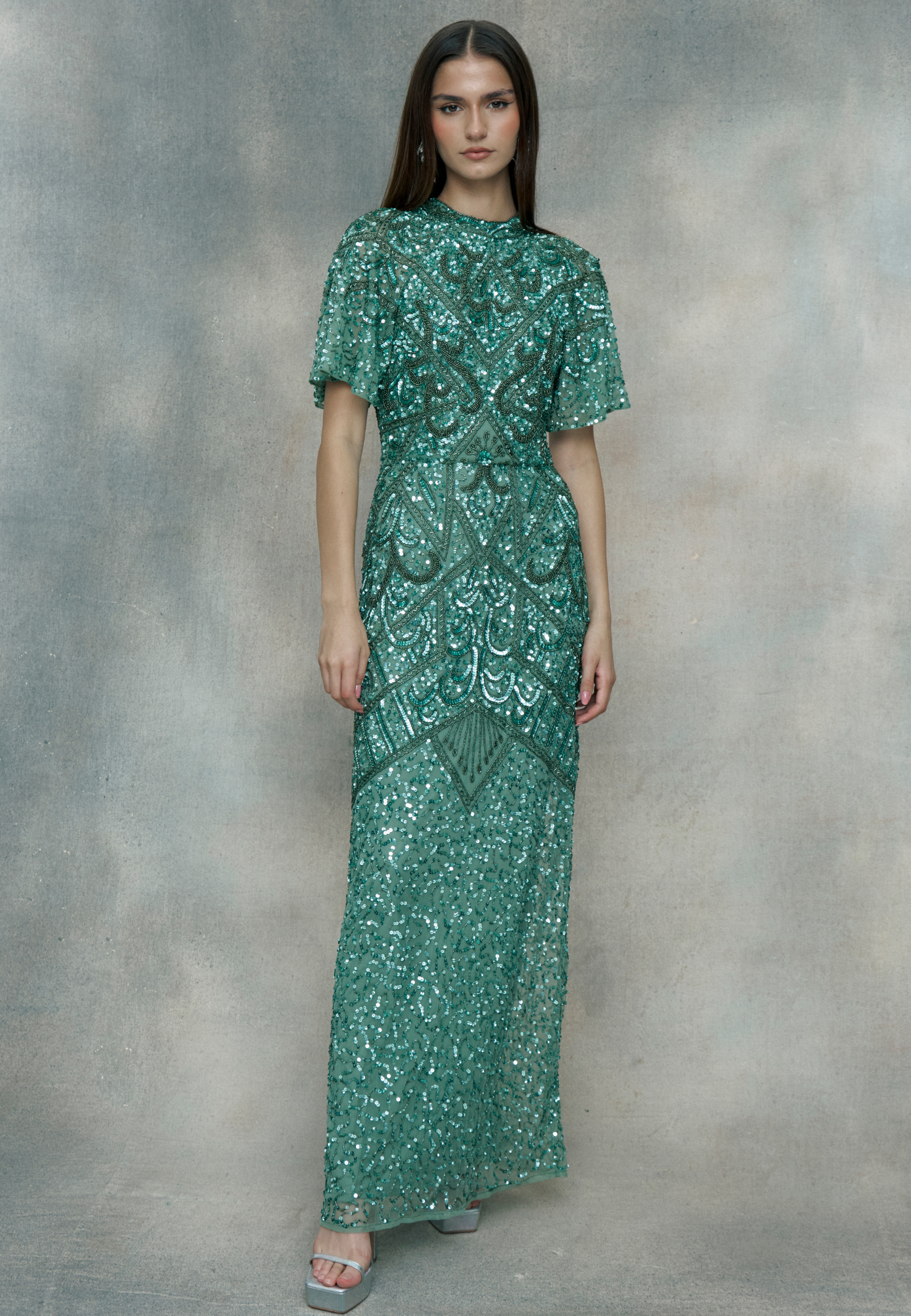 Woman wearing a green sequin dress, designed by BEAUUT