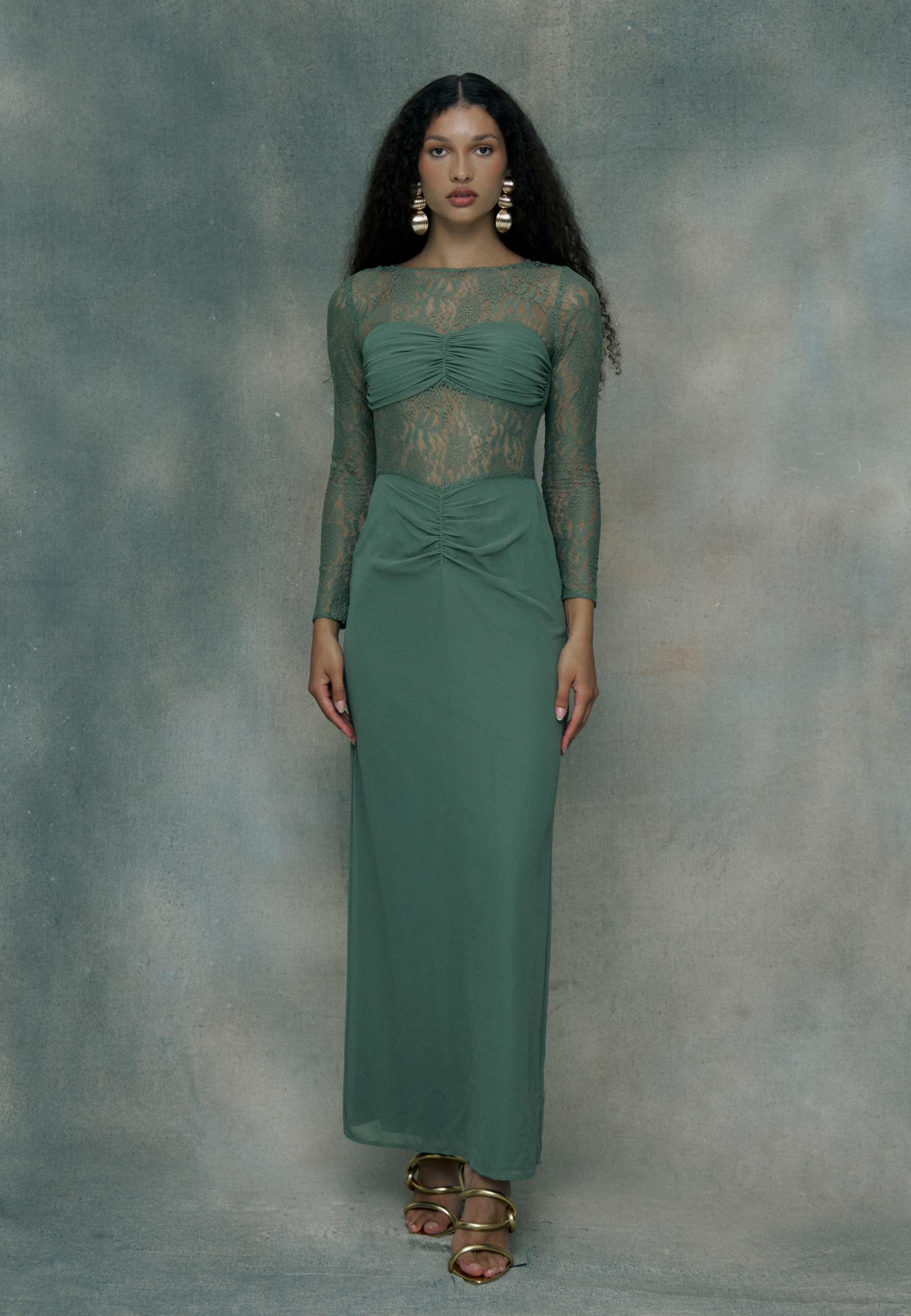 Woman wearing a green chiffon dress with long sleeves, designed by BEAUUT
