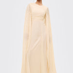 Woman wearing a light yellow dress with long sleeves on a white background