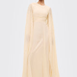 Woman wearing a light yellow dress with long sleeves on a white background