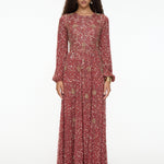 Woman wearing a long, patterned dress on a white background