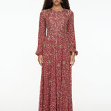 Woman wearing a long, patterned dress on a white background