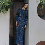 Woman in a blue sequin dress standing in a doorway, designed by MARYISA