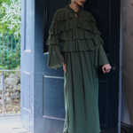 Woman in a green dress standing in front of a door, designed by Maryisa